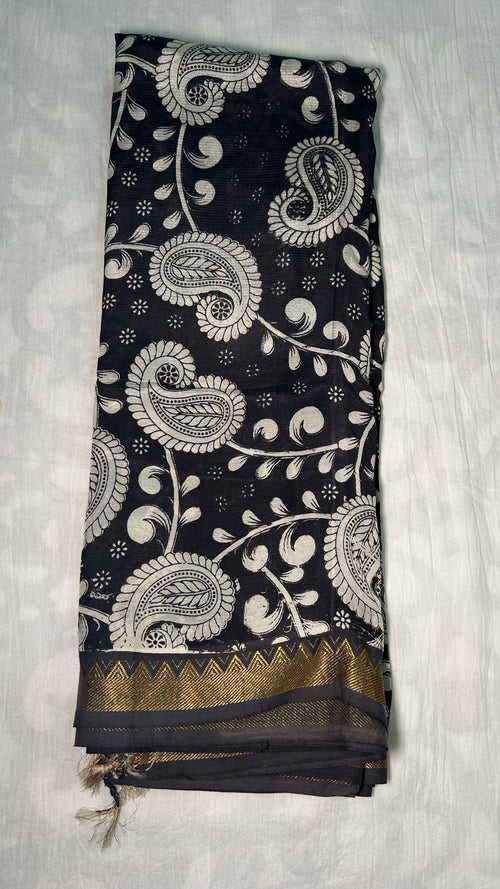 Black kalamkari saree fold showing gold zari nizam border and tassels